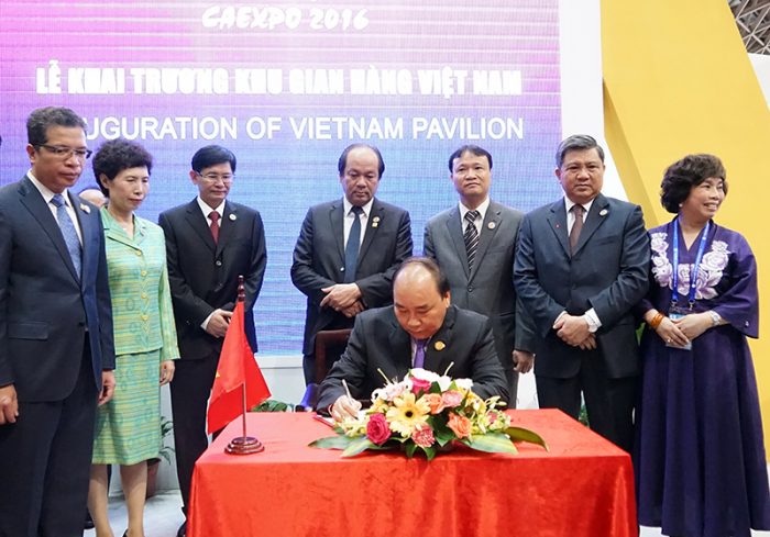 Thủ tướng viết lưu bút tại Khu gian hàng thương mại của DN Việt Nam. Ảnh: VGP/Quang Hiếu