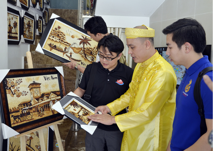 Đại diện tranh gạo Quỳnh Vy giới thiệu tranh gạo với các đại biểu