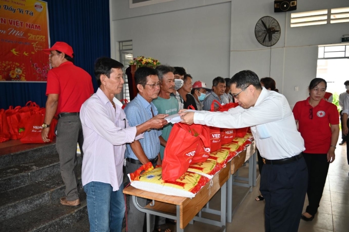 Ông Ni Chih Hao - Tổng giám đốc Công ty cổ phần hữu hạn Vedan Việt Nam (áo trắng) trao quà Tết cho bà con tại xã Tân Hiệp, huyện Long Thành. Ảnh: Vedan Việt Nam